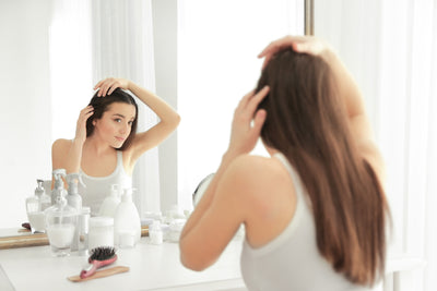 woman checking hair in mirror